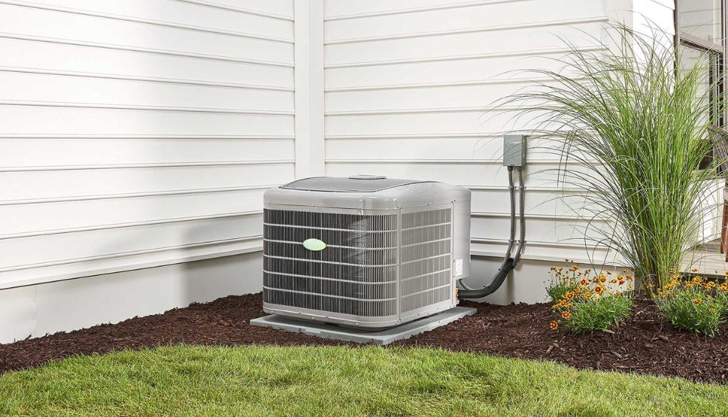 Air Central Austin outdoor HVAC unit next to a house with surrounding plants and grass.